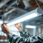 A photograph of a skilled lighting contractor expertly installing a sleek fluorescent light fixture in a modern workspace