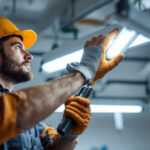 A photograph of a skilled lighting contractor demonstrating the proper technique for installing or adjusting fluorescent lights