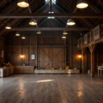 A photograph of a well-lit barn interior showcasing modern electric lighting installations
