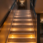 A photograph of a beautifully lit indoor staircase showcasing various lighting techniques