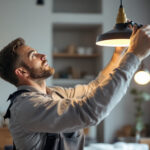 A photograph of a skilled lighting contractor expertly hanging a stylish light fixture in a well-lit