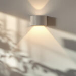 A photograph of a stylish white wall sconce light elegantly illuminating a modern interior space