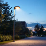 A photograph of a well-lit outdoor scene featuring a modern led pole light illuminating a pathway or public space