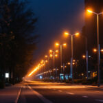 A photograph of a well-lit urban street scene featuring modern street pole lights illuminating the area