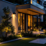 A photograph of a beautifully illuminated outdoor space featuring stylish light fixtures and well-designed landscaping