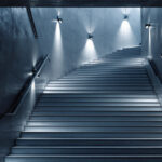 A photograph of a beautifully designed stairwell featuring modern light fixtures that illuminate the space