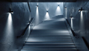 A photograph of a beautifully designed stairwell featuring modern light fixtures that illuminate the space
