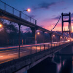A photograph of a well-lit bridge at dusk