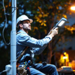 A photograph of a lighting contractor installing an led pole light in an outdoor setting