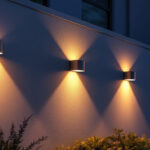 A photograph of a beautifully illuminated exterior wall featuring various styles of wall mount lights in a residential setting