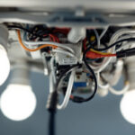 A photograph of a close-up of a 4-bulb light fixture with the ballast exposed