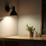 A photograph of a stylish wall corner lamp illuminating a cozy interior space