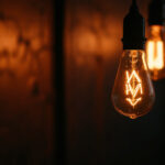A photograph of a close-up of a flickering bulb lamp in a dimly lit environment