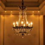 A photograph of a beautifully designed chandelier lamp in an elegantly lit room
