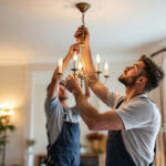 A photograph of a lighting contractor carefully installing a chandelier in an elegantly designed space