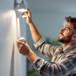 A photograph of a skilled lighting contractor installing led can lights in a modern home setting