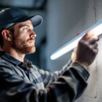 A photograph of a lighting contractor installing or adjusting a sleek
