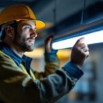 A photograph of a lighting contractor installing or examining led t5 lamps in a commercial or residential setting
