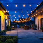 A photograph of a well-lit outdoor workspace featuring a lighting contractor installing led shop lights