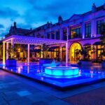 A photograph of a beautifully illuminated outdoor space featuring blue lighting