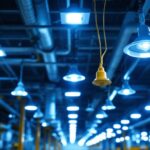 A photograph of a well-lit commercial or industrial lighting installation showcasing various types of lighting ballasts in use
