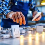 A photograph of a lighting contractor examining various led dimmer switches in a well-lit workspace