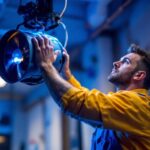 A photograph of a skilled lighting contractor installing a cyclone fan in a well-lit space