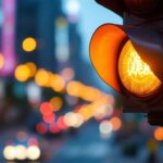 A photograph of a close-up of a vibrant traffic light with its bulbs illuminated against a backdrop of a bustling city street