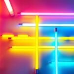 A photograph of a vibrant display of various coloured fluorescent tube lights arranged artistically in a well-lit workspace