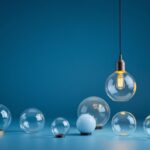 A photograph of a stylish pendant light with a variety of replacement globes displayed around it