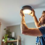 A photograph of a skilled lighting contractor installing a stylish ceiling can light cover in a modern home setting