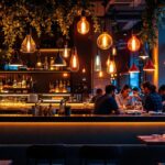 A photograph of a beautifully illuminated restaurant interior showcasing various lighting designs and fixtures