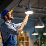 A photograph of a skilled electrician or lighting technician installing a&h lighting fixtures in a modern space