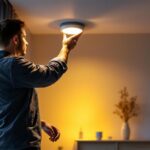 A photograph of a skilled lighting contractor installing recessed led pot lights in a modern home setting