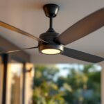 A photograph of a stylish outdoor ceiling fan with sleek metal blades installed on a patio or porch