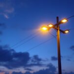 A photograph of a modern power pole illuminated by energy-efficient led lights at dusk