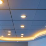 A photograph of a well-lit drop ceiling installation featuring recessed lighting