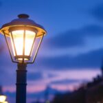 A photograph of a well-designed light pole light fixture illuminating a vibrant urban environment at dusk