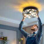 A photograph of a skilled lighting contractor expertly installing a stylish ceiling light fixture in a modern living space