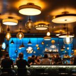 A photograph of a stylish bar interior featuring various ceiling light designs