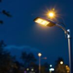 A photograph of a well-lit security light pole installed in a commercial or residential setting