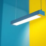 A photograph of a modern linear hanging light fixture installed in a well-lit space