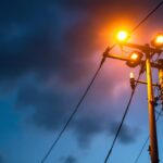 A photograph of a well-lit utility pole at dusk