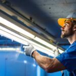 A photograph of a lighting contractor installing led fixtures in a commercial space