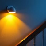 A photograph of a beautifully designed wall-mounted stairwell light fixture illuminating a staircase