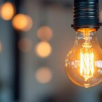 A photograph of a close-up of a glowing 120v 60w light bulb in a stylish fixture