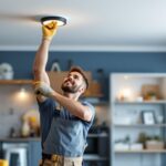 A photograph of a skilled lighting contractor installing recessed ceiling lights in a modern home setting