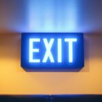 A photograph of a modern commercial exit sign illuminated in a stylishly designed interior space