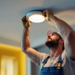 A photograph of a skilled lighting contractor installing a sleek 5-inch recessed light in a modern ceiling