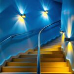 A photograph of a well-lit stairwell featuring stylish and functional lighting fixtures